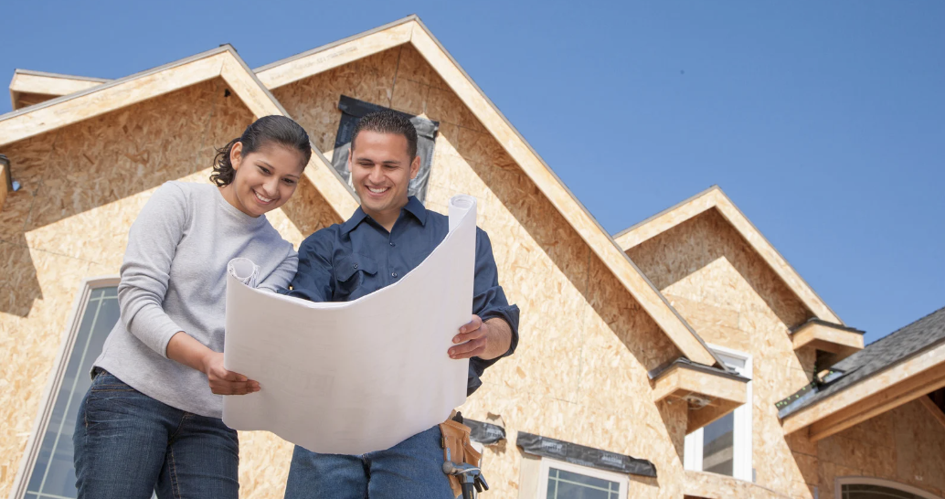 Homebuyers excitedly reviewing their new construction build plans