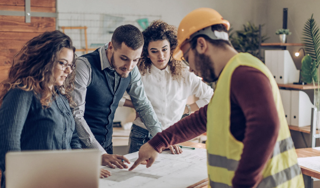 Homebuyers talking over plans with their home builder and real estate agent