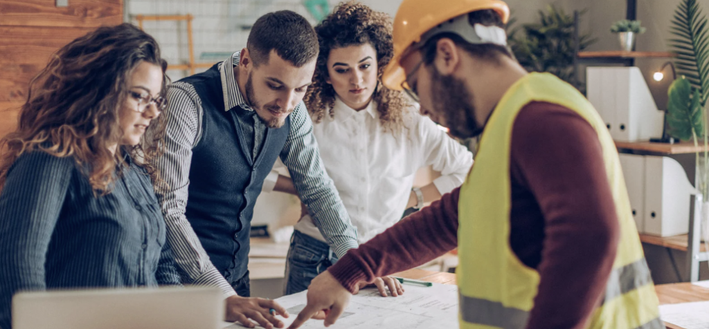 Homebuyers talking over plans with their home builder and real estate agent